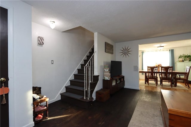 stairs featuring wood-type flooring and a textured ceiling