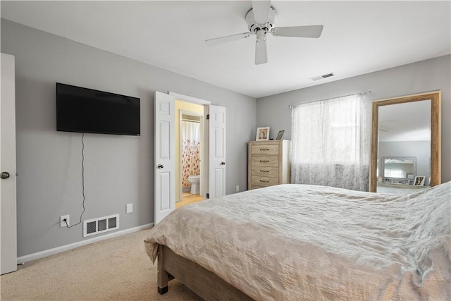 bedroom featuring connected bathroom, ceiling fan, and light carpet