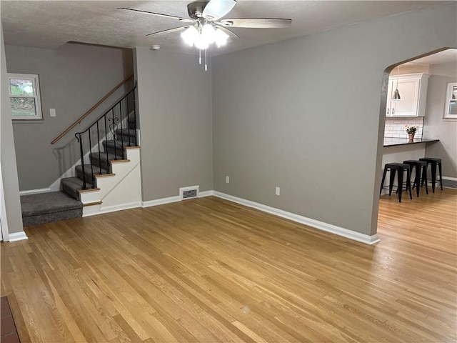 unfurnished living room with light hardwood / wood-style floors and ceiling fan