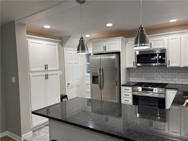 kitchen featuring backsplash, white cabinetry, hanging light fixtures, and appliances with stainless steel finishes