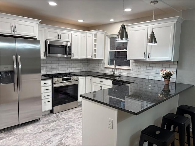 kitchen with kitchen peninsula, decorative light fixtures, decorative backsplash, white cabinets, and appliances with stainless steel finishes