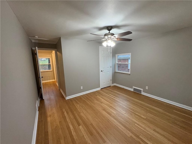 spare room featuring ceiling fan, plenty of natural light, and light wood-type flooring