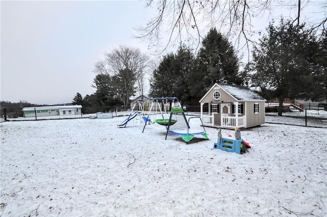 snow covered playground with an outbuilding