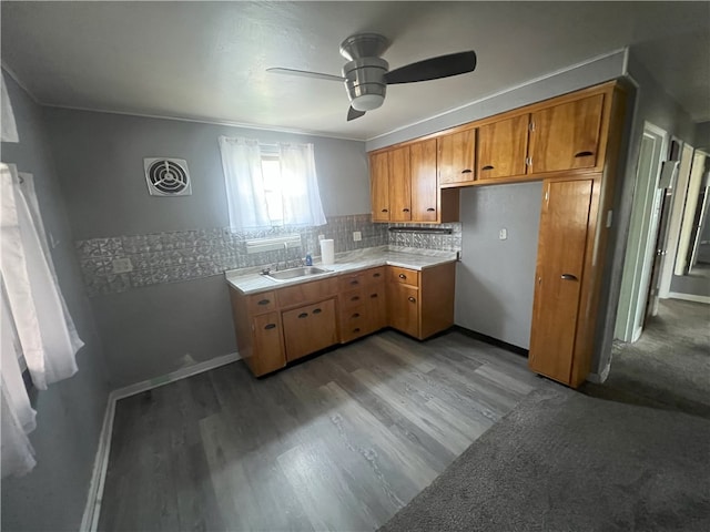 kitchen featuring decorative backsplash, ornamental molding, ceiling fan, sink, and light hardwood / wood-style floors