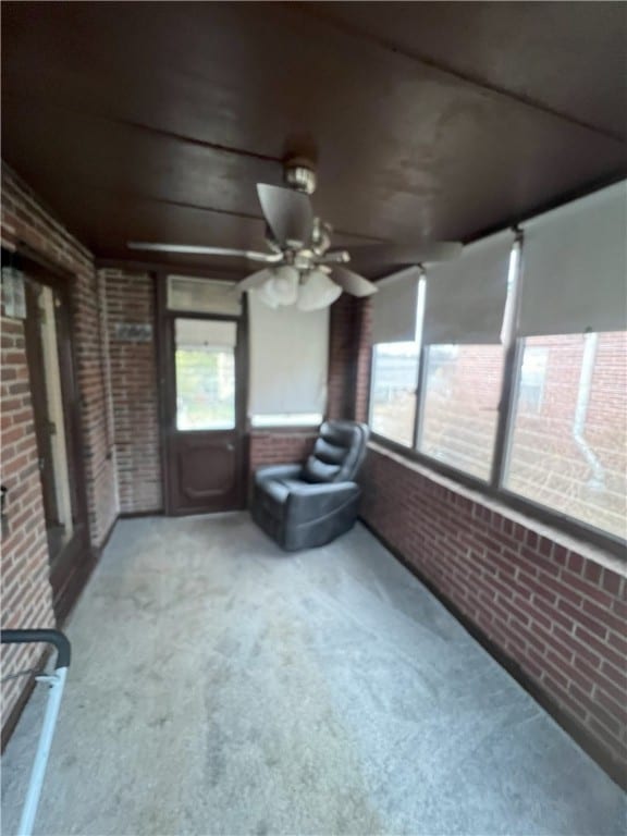 unfurnished sunroom with ceiling fan