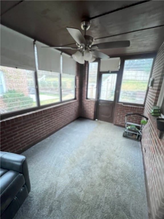 unfurnished sunroom featuring ceiling fan