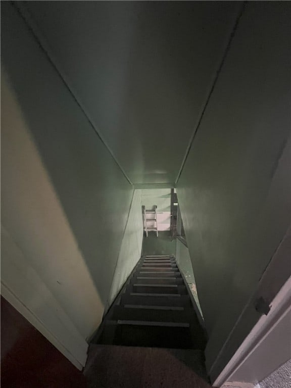 stairs with carpet floors and lofted ceiling