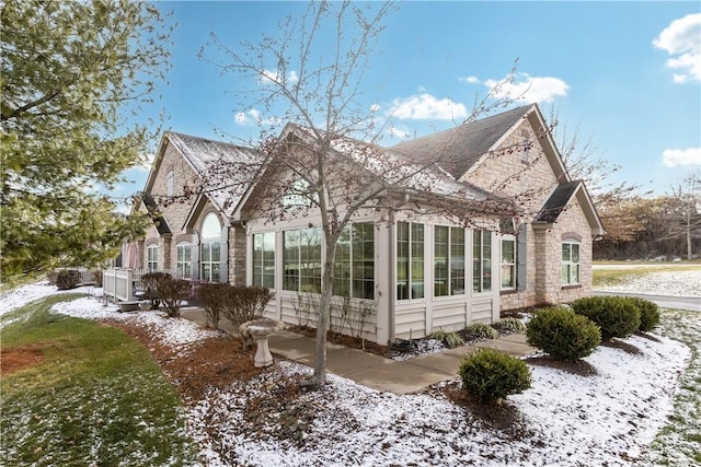 view of snowy exterior featuring a sunroom