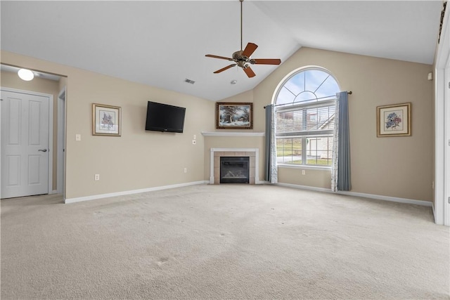 unfurnished living room featuring a tile fireplace, light colored carpet, high vaulted ceiling, and ceiling fan