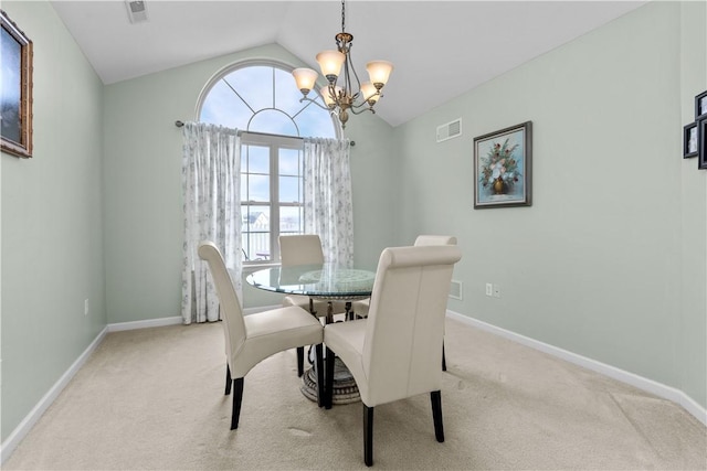 dining area featuring a chandelier, light carpet, and vaulted ceiling