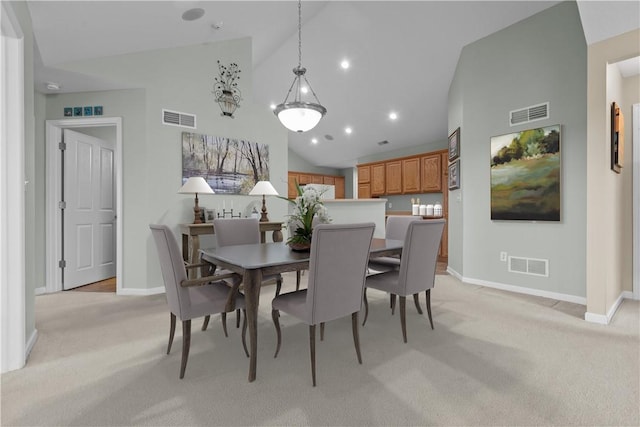 dining space featuring light colored carpet and lofted ceiling