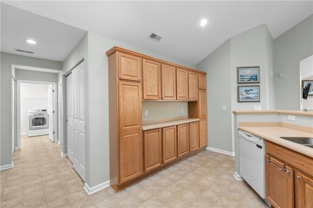 kitchen with dishwasher, lofted ceiling, and washer / clothes dryer