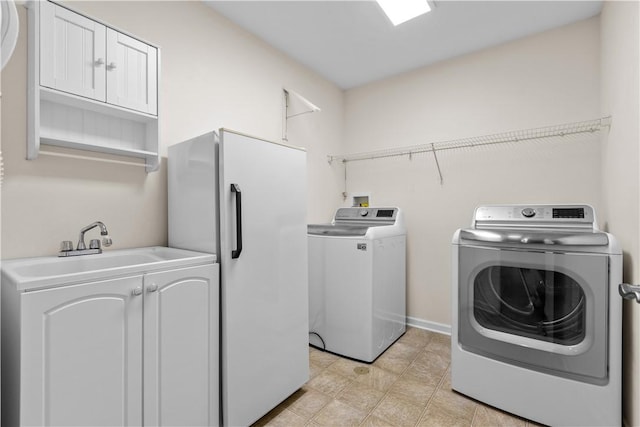 washroom with washer and clothes dryer and cabinets