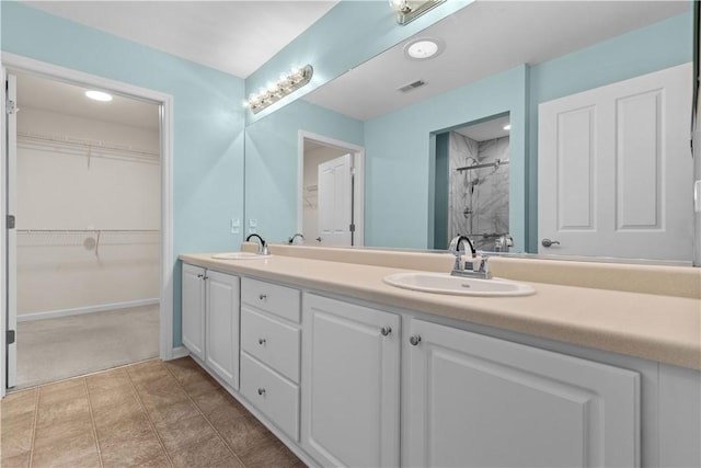 bathroom featuring tile patterned floors, vanity, and a tile shower