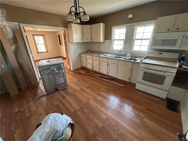 kitchen featuring light hardwood / wood-style floors, white appliances, hanging light fixtures, and an inviting chandelier