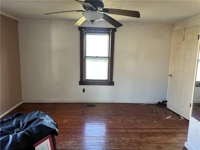 empty room featuring crown molding, dark hardwood / wood-style flooring, and ceiling fan