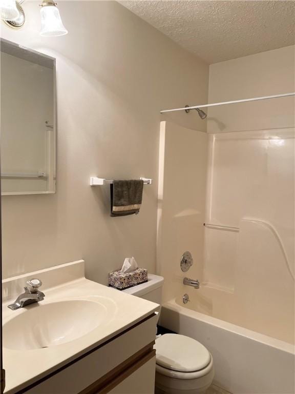 full bathroom with vanity, a textured ceiling, toilet, and  shower combination