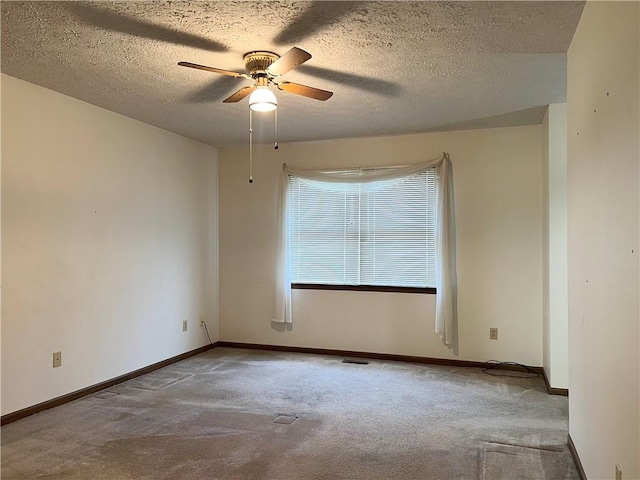 carpeted empty room featuring ceiling fan and a textured ceiling