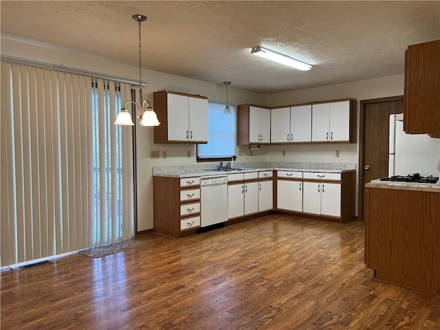 kitchen with white appliances, decorative light fixtures, white cabinetry, and dark wood-type flooring