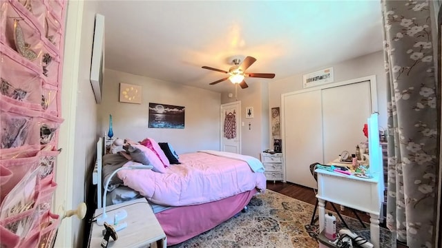 bedroom with ceiling fan, dark hardwood / wood-style floors, and a closet