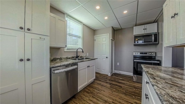 kitchen with stone counters, white cabinets, sink, dark hardwood / wood-style floors, and appliances with stainless steel finishes