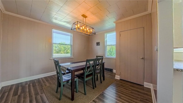 dining space with ornamental molding, dark wood-type flooring, and a notable chandelier