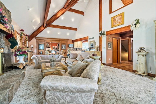 living room featuring beam ceiling, a fireplace, high vaulted ceiling, and light hardwood / wood-style floors