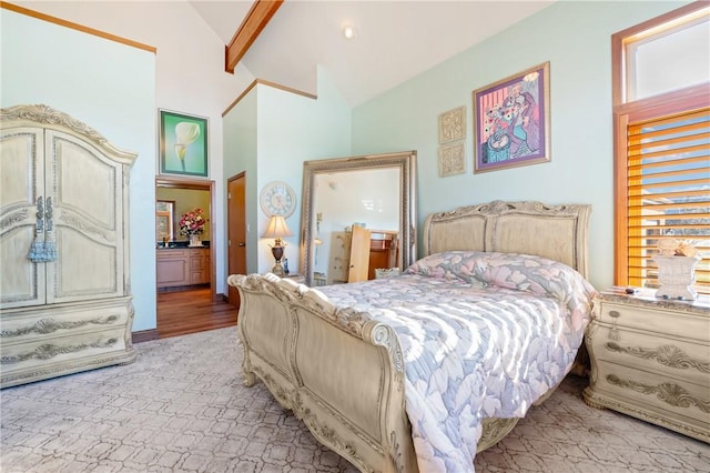 bedroom with lofted ceiling with beams, light hardwood / wood-style flooring, and ensuite bath