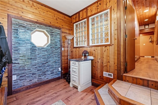 office featuring wooden walls, crown molding, and light hardwood / wood-style floors