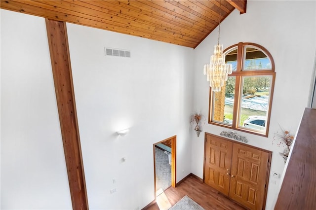 entryway with high vaulted ceiling, beamed ceiling, a notable chandelier, light hardwood / wood-style floors, and wood ceiling