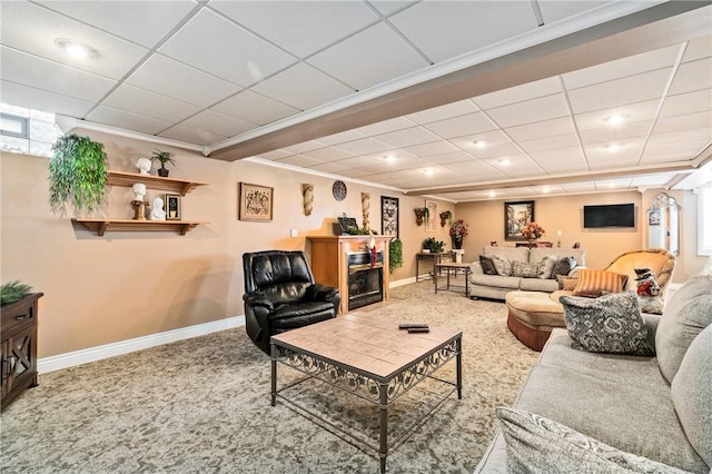 living room featuring carpet, a drop ceiling, and ornamental molding