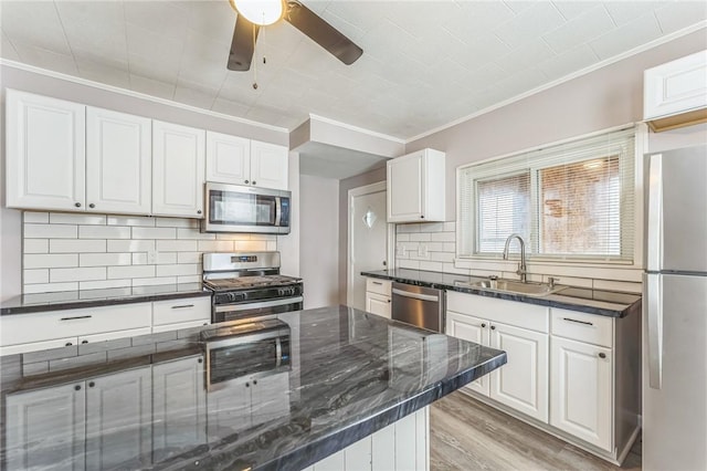 kitchen featuring backsplash, white cabinets, sink, light hardwood / wood-style flooring, and appliances with stainless steel finishes