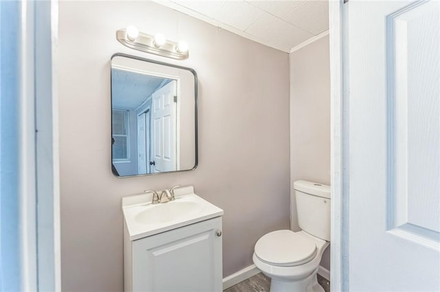 bathroom featuring hardwood / wood-style floors, vanity, ornamental molding, and toilet