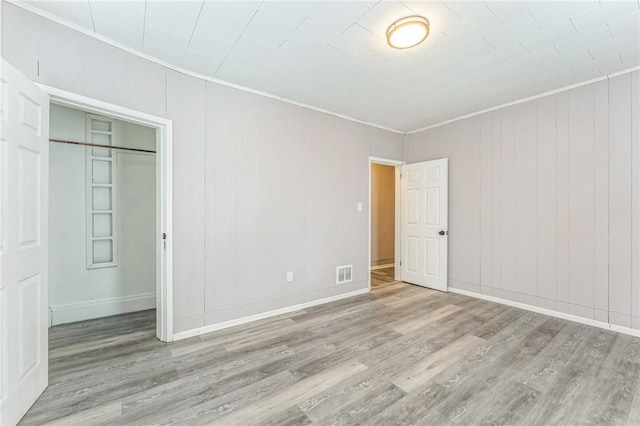 empty room featuring light hardwood / wood-style floors and ornamental molding