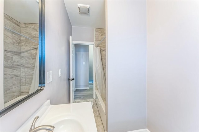 bathroom with hardwood / wood-style floors, walk in shower, and sink