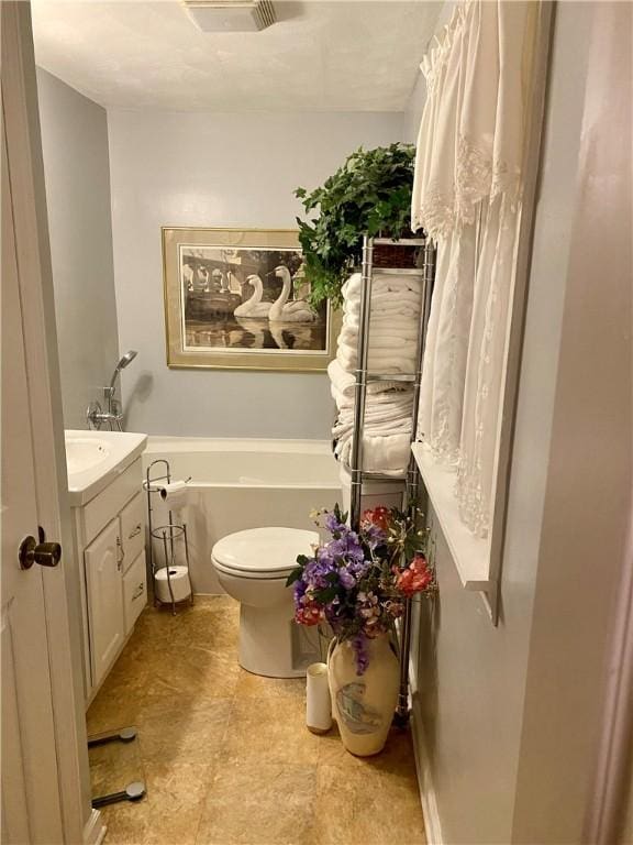 bathroom featuring vanity, visible vents, toilet, and a bathtub