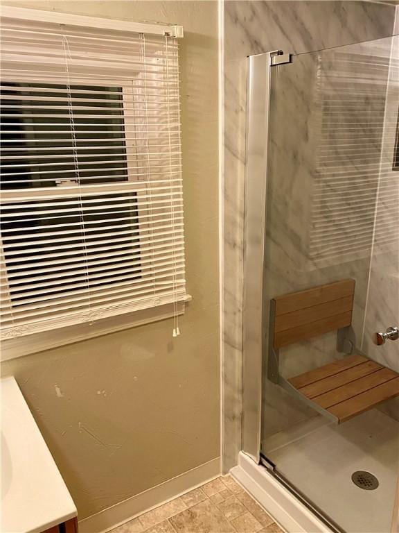 bathroom featuring baseboards and a stall shower