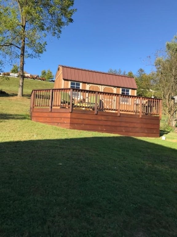 back of property with a lawn and a wooden deck