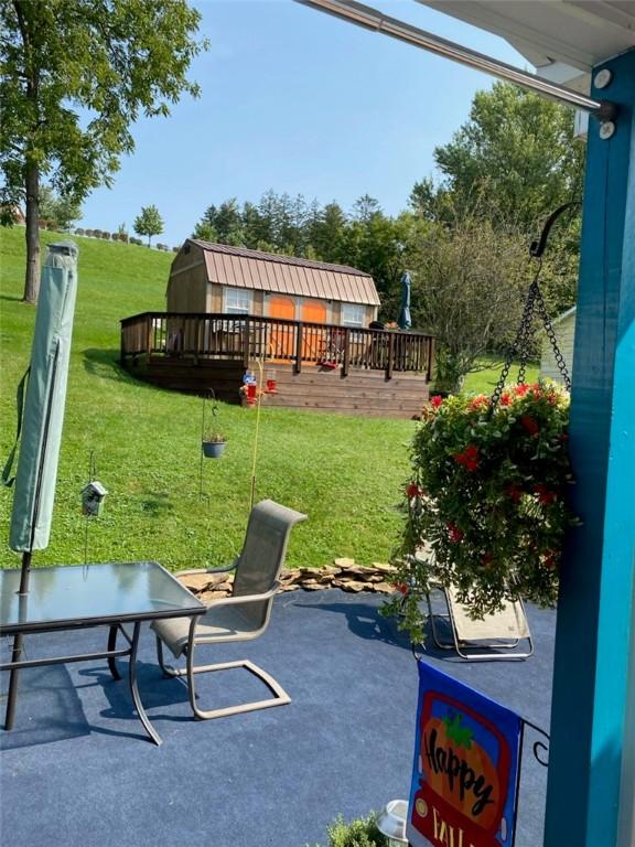 view of patio / terrace with a storage shed and an outbuilding