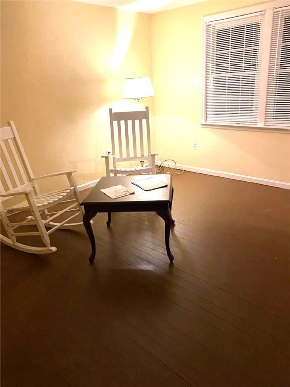 living area with baseboards and hardwood / wood-style flooring