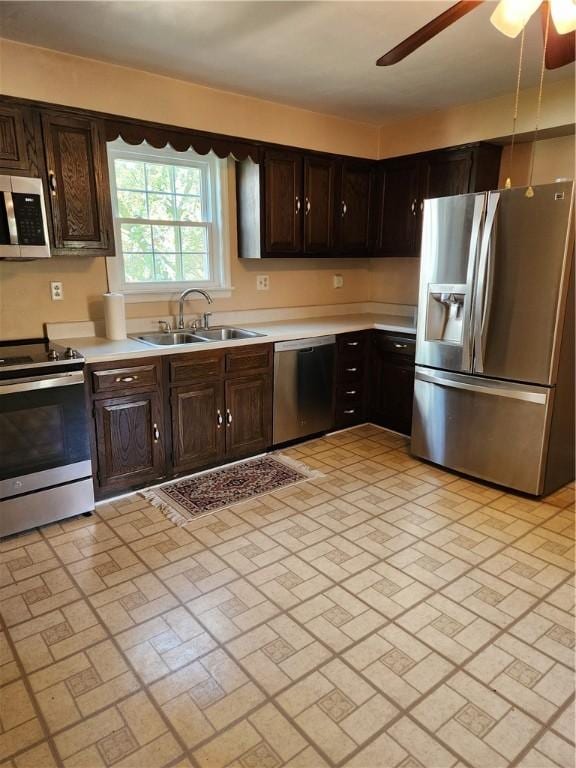 kitchen with a sink, light countertops, stainless steel appliances, and brick patterned floor