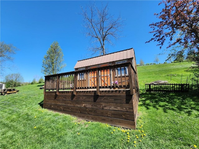rear view of property with a lawn, a wooden deck, and metal roof