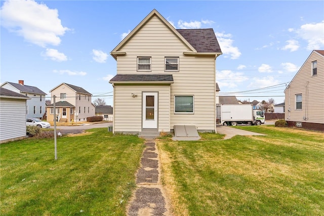 rear view of house featuring a yard