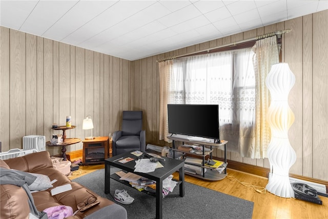 living room with hardwood / wood-style floors and wood walls