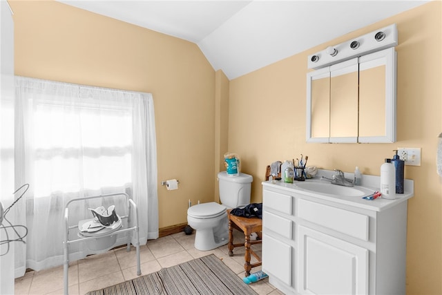 bathroom featuring tile patterned flooring, vanity, lofted ceiling, and toilet