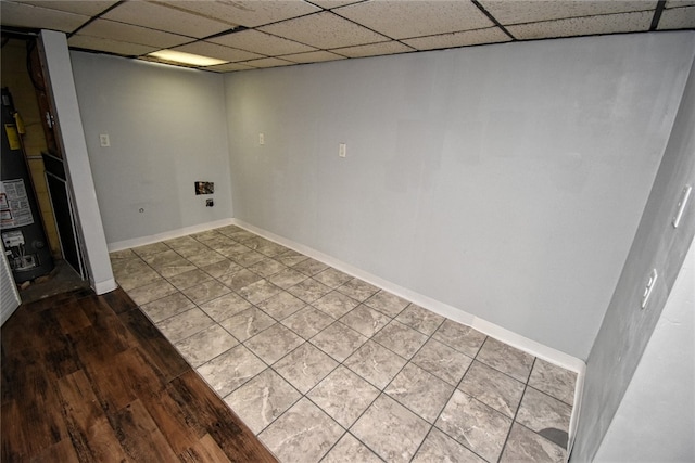 basement with a paneled ceiling and wood-type flooring