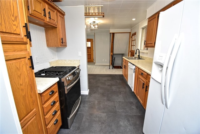 kitchen featuring sink, dark tile patterned flooring, and white appliances