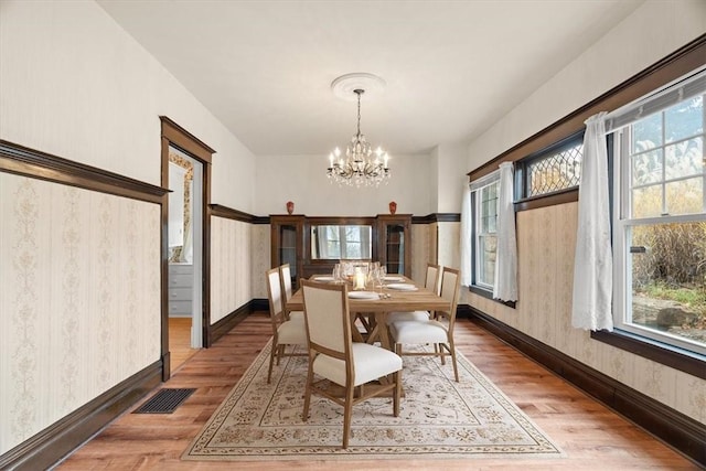 dining space with dark hardwood / wood-style floors and an inviting chandelier