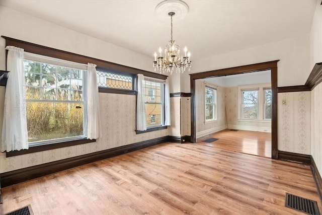 interior space with light hardwood / wood-style floors, an inviting chandelier, and plenty of natural light