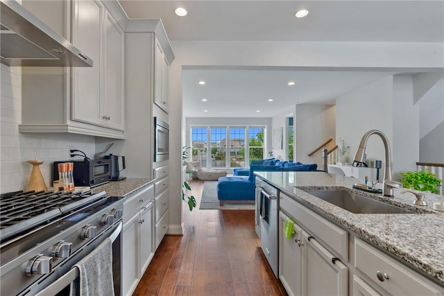 kitchen featuring white cabinetry, sink, wall chimney exhaust hood, stainless steel appliances, and dark hardwood / wood-style flooring